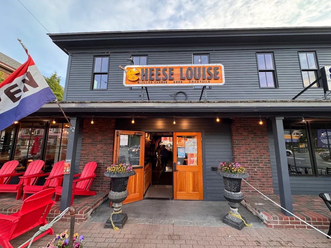 Cheese Louise restaurant exterior in North Conway, New Hampshire with red chairs and flower planters