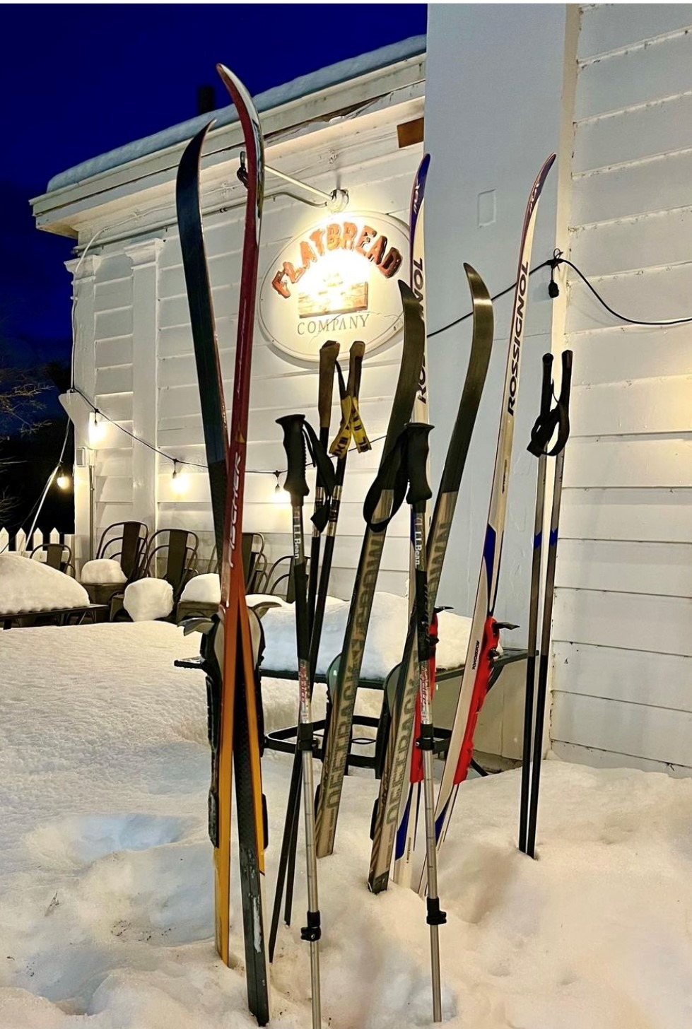 Flatbread Company restaurant exterior in North Conway, New Hampshire with skis out front in the snow